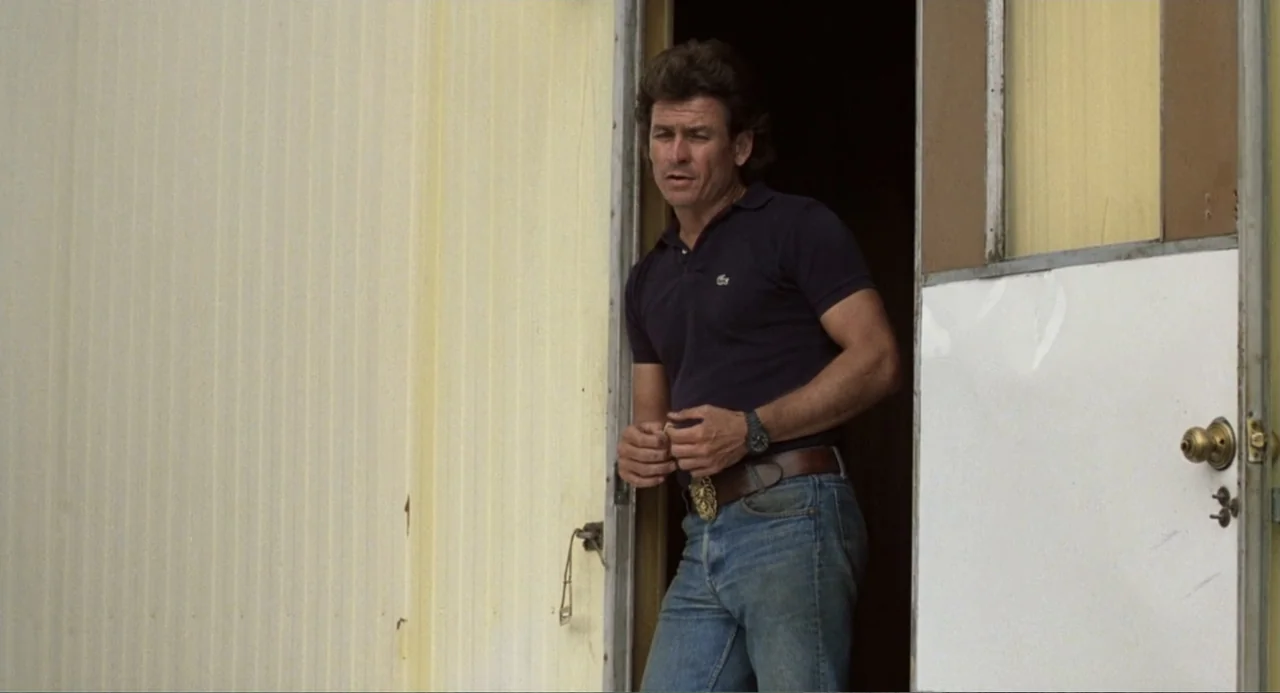 Harry and the Butler (1961) movie still: medium — A man stands in the open doorway of a weathered modular trailer exterior. The subject wears a dark…
