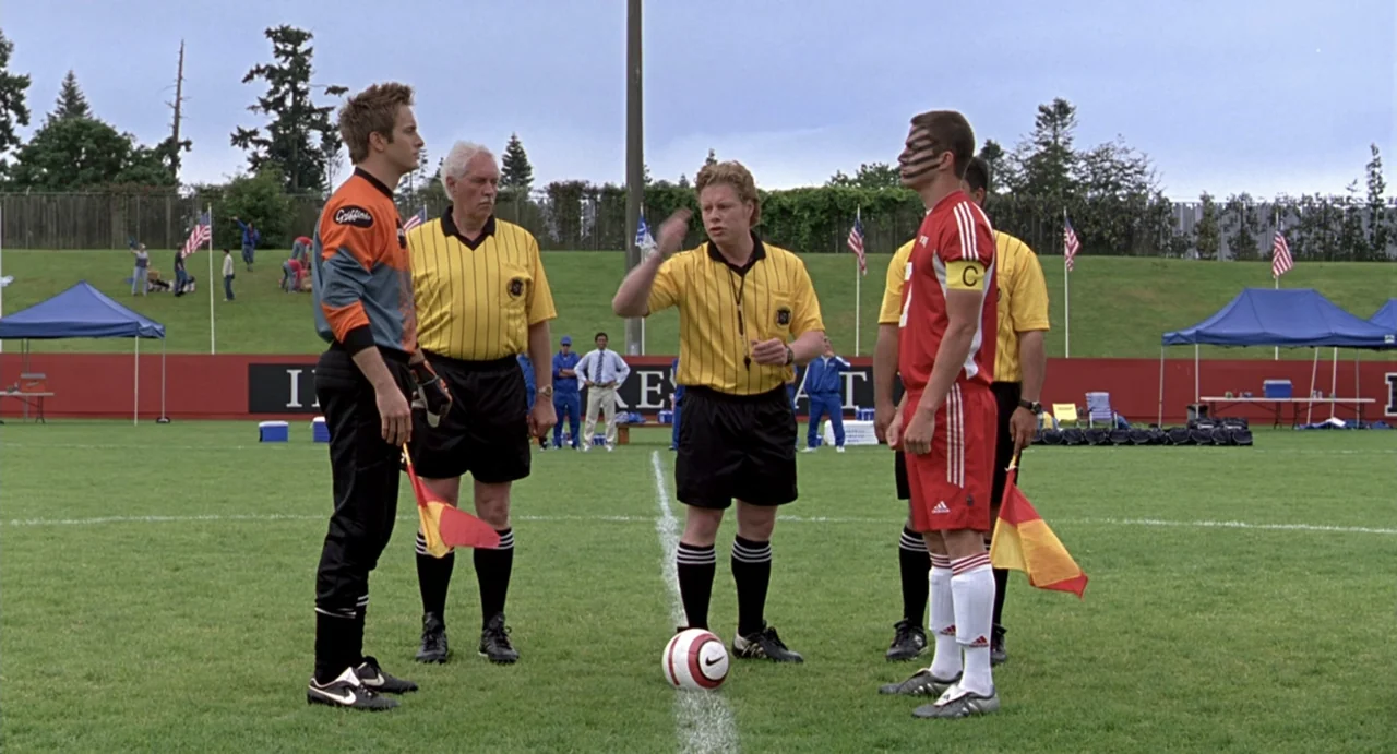She's the Man (2006) movie still: fullbody — A manicured soccer pitch features painted white lines and a large red perimeter wall. Two soccer…