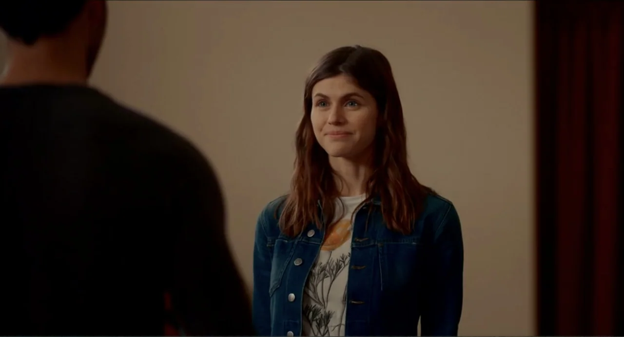 Can You Keep a Secret? (2019) movie still: medium — An interior space with beige walls and a person in the foreground. A woman stands in the middle…