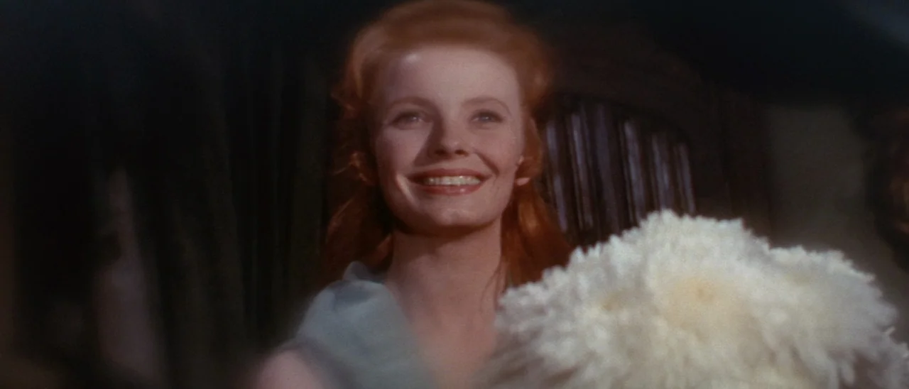 The Tomb of Ligeia (1964) movie still: closeup — A dimly lit indoor space with dark background elements and a wooden structure. A young woman with…