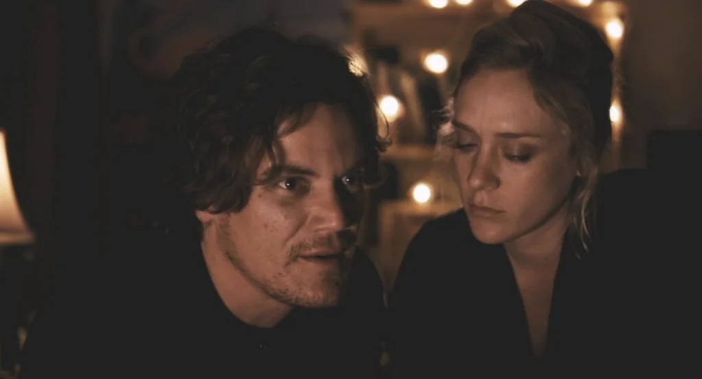 My Son, My Son, What Have Ye Done? (2009) movie still: medium — An interior space is dimly lit by strings of small warm fairy lights. A man and a…