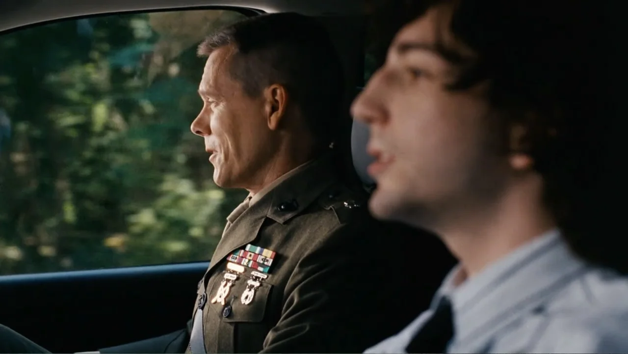 Taking Chances (2011) movie still: medium — The interior of a moving car shows two men engaged in a conversation. An older man in uniform sits in…