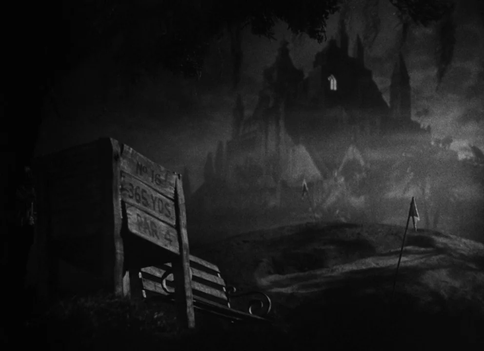 Citizen Kane (1941) movie still: wide — A dark, misty golf course exterior features a wooden distance marker at night. A large, shadowy mansion…
