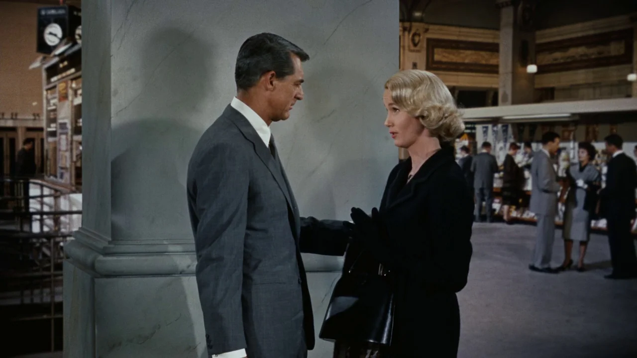 North By Northwest (1959) movie still: medium — A spacious, polished train station terminal featuring massive marble columns and distant commuters.…