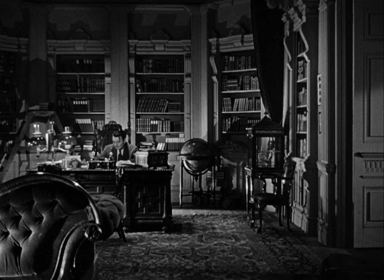 The Spiral Staircase (1946) movie still: wide — A large, wood-paneled library features floor-to-ceiling bookshelves and ornate antique furniture. A…