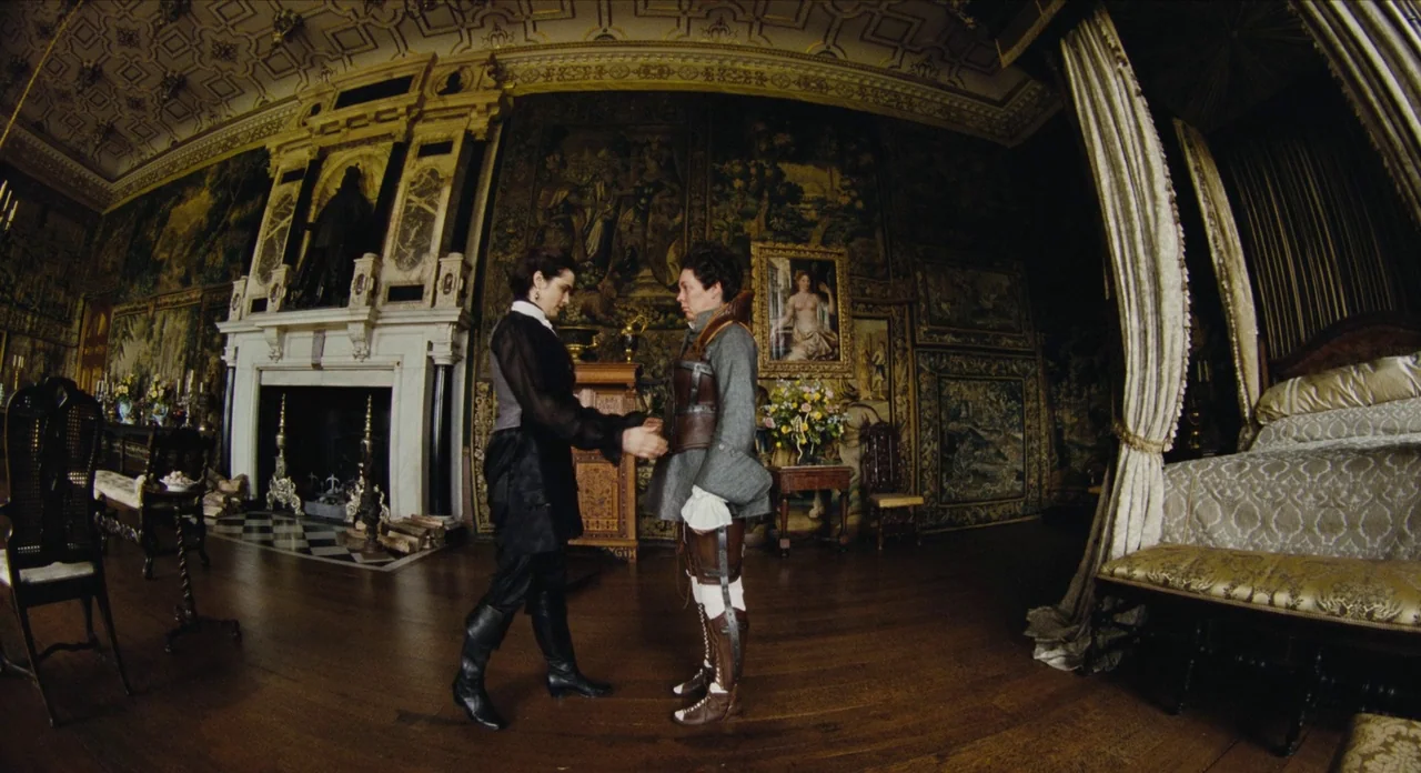 The Favourite (2018) movie still: wide — A spacious, opulent 18th-century chamber features ornate tapestries, dark wood flooring, and a large…
