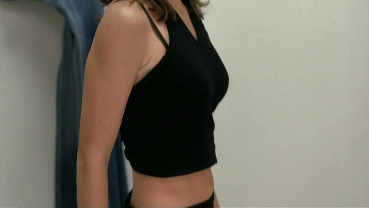 White Chicks (2004) movie still: medium — A minimalist white room features a single wall with a denim garment hanging. A young woman in a black…