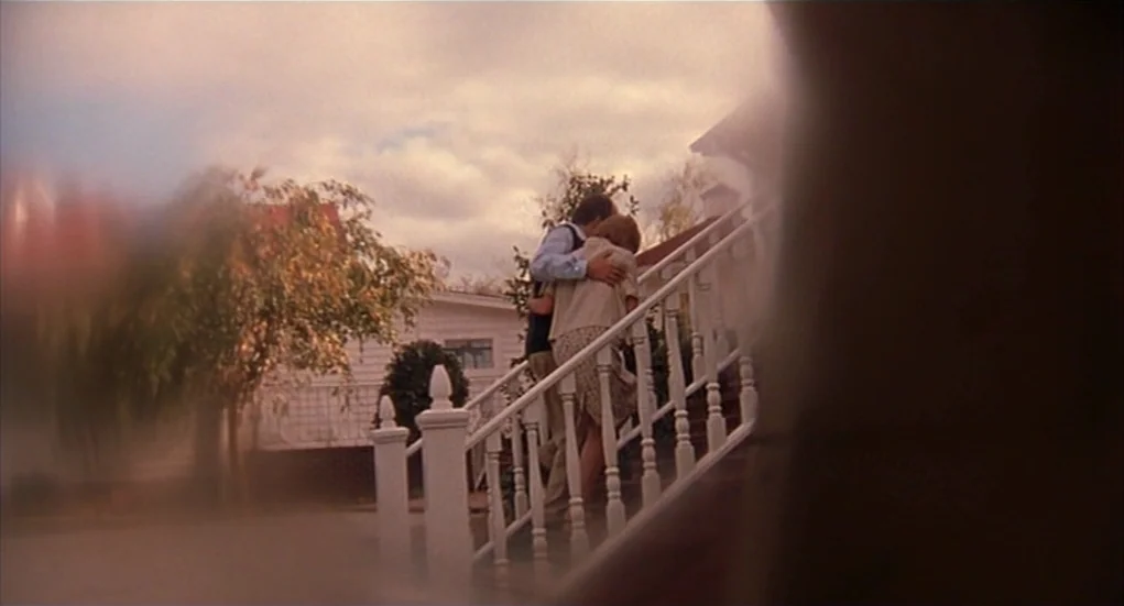 The Heart Is Deceitful Above All Things (2004) movie still: wide — A wooden staircase leads to the front porch of a white clapboard house. A man and…