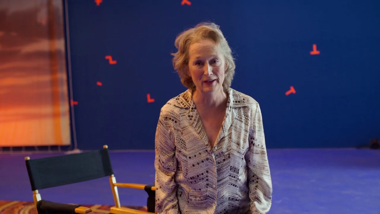 The Laundromat (2019) movie still: medium — A film studio environment with blue walls featuring red motion tracking markers. A woman stands beside a…