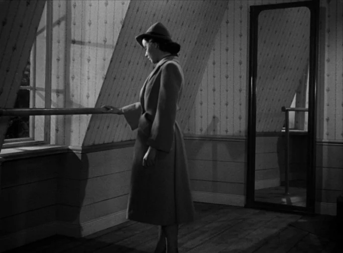 Summer Interlude (1951) movie still: fullbody — An attic room features sloped walls with vertical striped wallpaper and a full-length mirror. A…