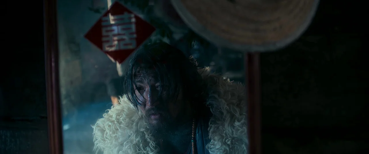 One And Four (2021) movie still: closeup — A man in a fur-lined coat gazes into a framed mirror in a dark space. A red Chinese paper cutout…