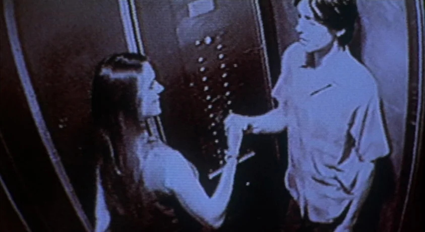 Requiem For A Dream (2000) movie still: medium — A surveillance camera feed inside an elevator shows the interior control panel and walls. A young…