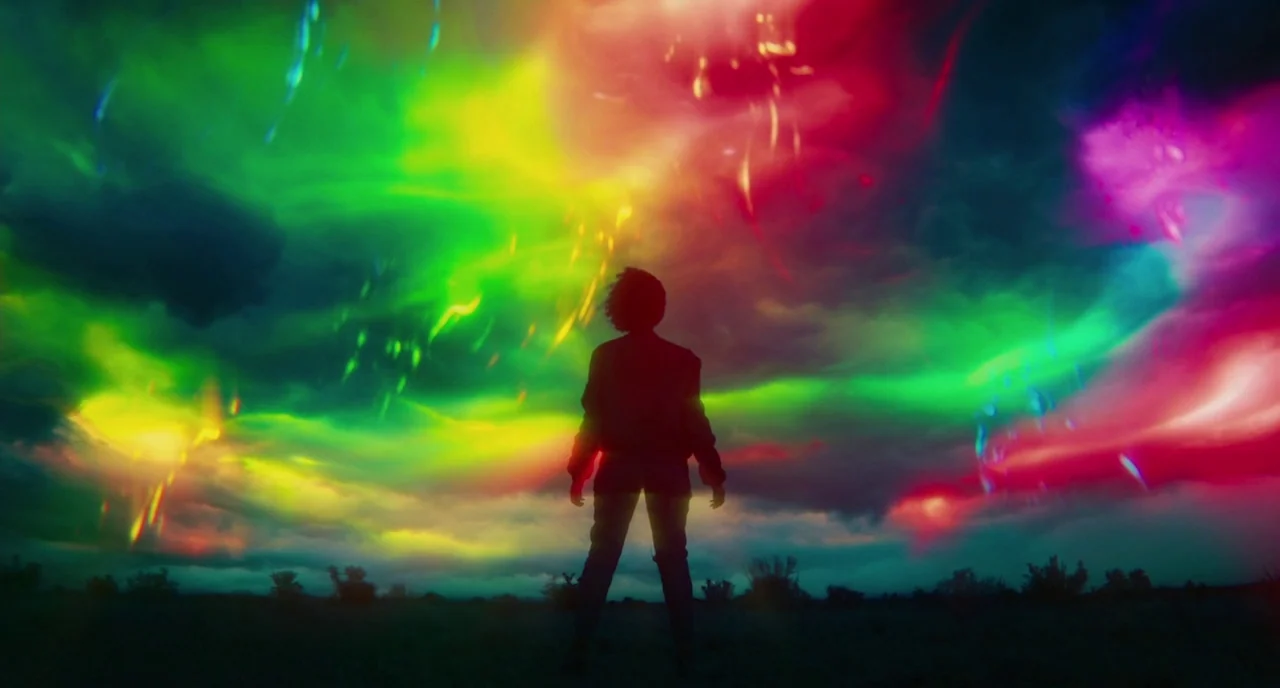 Fast Color (2018) movie still: fullbody — An open rural field under a dark night sky filled with intense colorful lights. A single person stands in…
