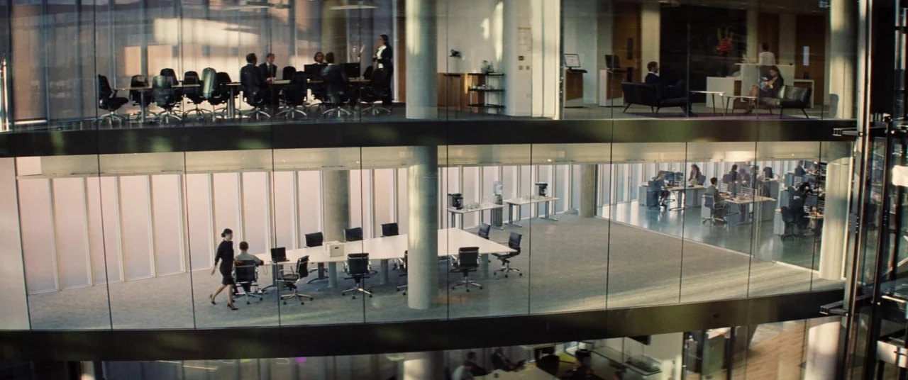 Mission: Impossible – Rogue Nation (2015) movie still: establishing — A multi-level modern glass-walled office building features various workspaces…