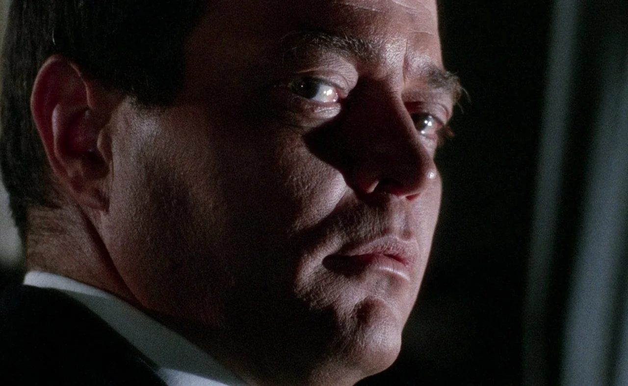 Blood And Black Lace (1964) movie still: closeup — A dark indoor setting with limited illumination highlighting a man's face. The subject stares…