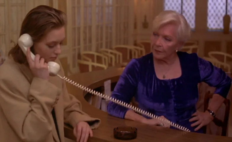 I Can’t Sleep (1994) movie still: medium — An interior space with a wood-finished counter and multiple chairs in the blurred background. A young…