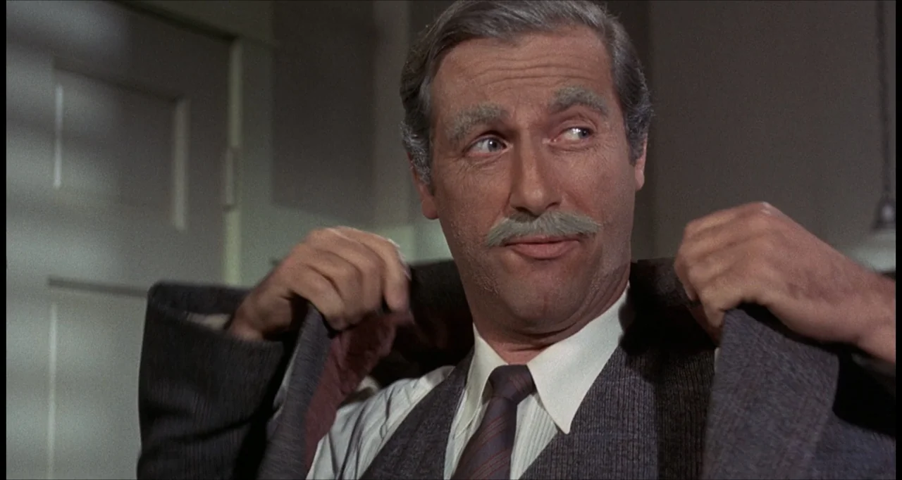 The Dunwich Horror (1970) movie still: closeup — A man in a dress shirt and vest stands in an indoor setting. He is looking to the side while…