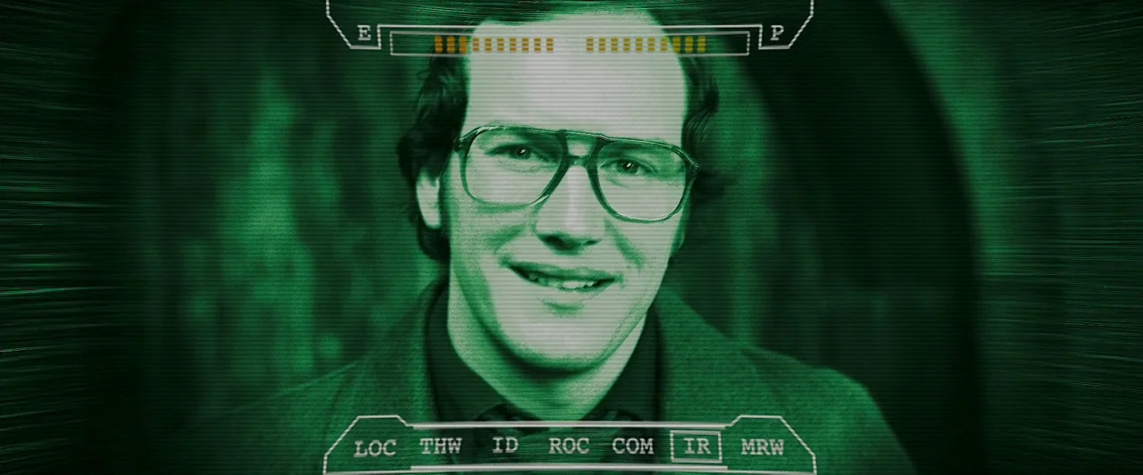 Watchmen (2009) movie still: closeup — A head-and-shoulders portrait of a man framed by an electronic green night-vision interface overlay. The…