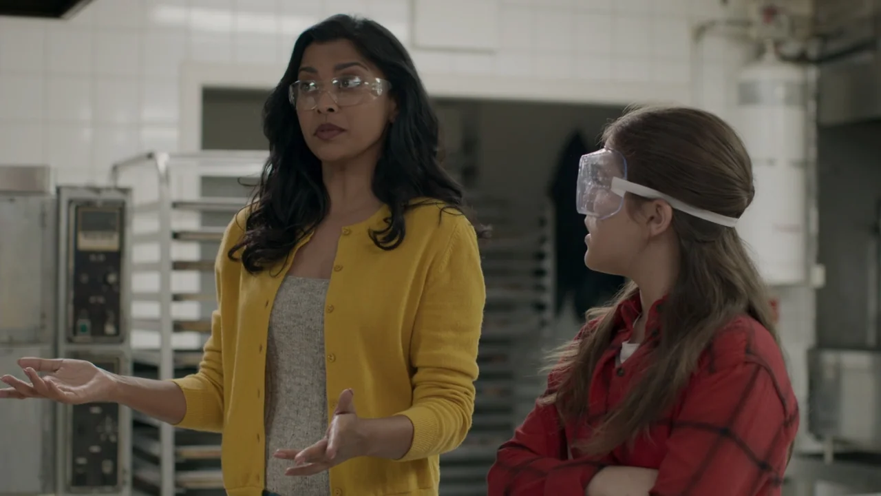 A Gingerbread Christmas (2022) movie still: medium — A professional kitchen features white tiled walls and stainless steel food service equipment.…