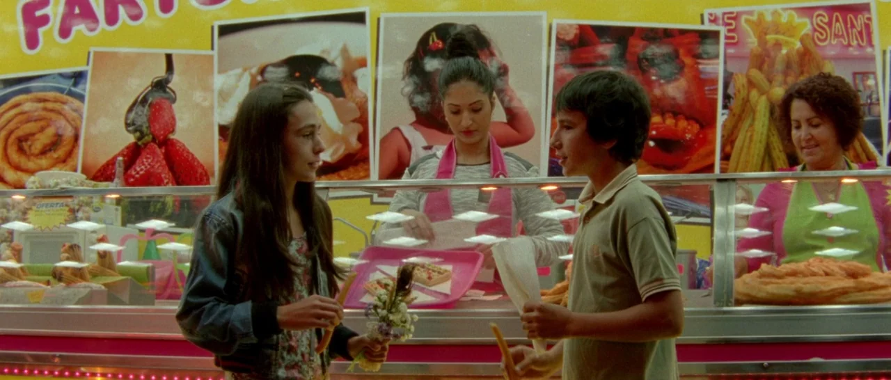 Arabian Nights: Volume 1 – The Restless One (2015) movie still: medium — A brightly lit snack bar stall displays advertisements of food behind a…