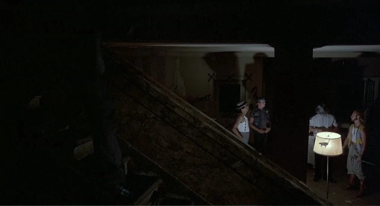 Death Wish II (1982) movie still: wide — A dark, dilapidated interior space features graffiti-marked walls and a large, slanted wooden structure.…