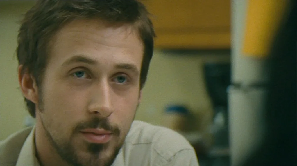 Half Nelson (2006) movie still: closeup — A man stands in an out-of-focus indoor space with blurred furniture in the background. The man looks…