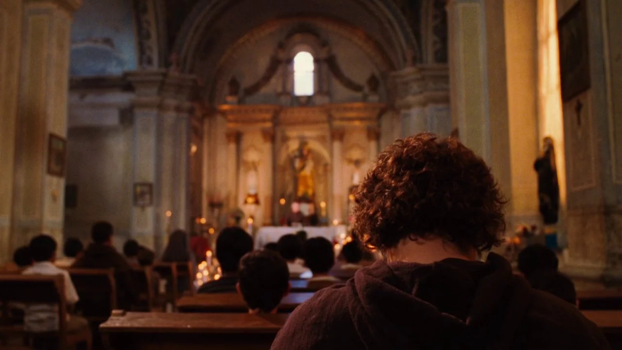 Nacho Libre (2006) movie still: medium — A dimly lit church interior with rows of wooden pews facing a distant altar. A young person with curly hair…
