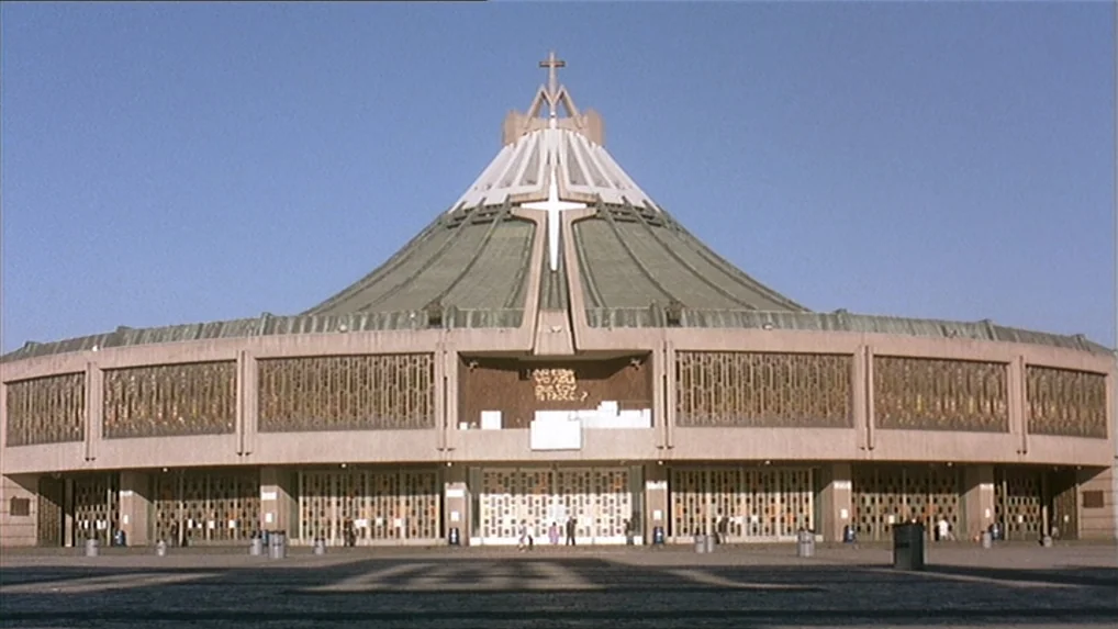 Battle In Heaven (2005) movie still: establishing — The massive, circular concrete Basilica of Our Lady of Guadalupe features a wide, low-slung…