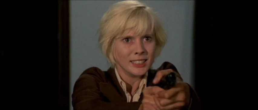 Four Flies On Grey Velvet (1971) movie still: closeup — An indoor space with a plain, neutral-colored wall behind the subject. A person with blonde…