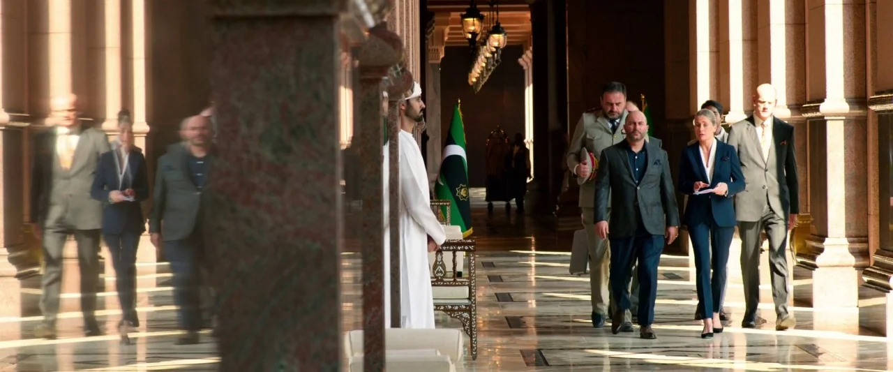 6 Underground (2019) movie still: wide — A long, ornate corridor with polished stone floors and large marble columns on both sides. A group of…