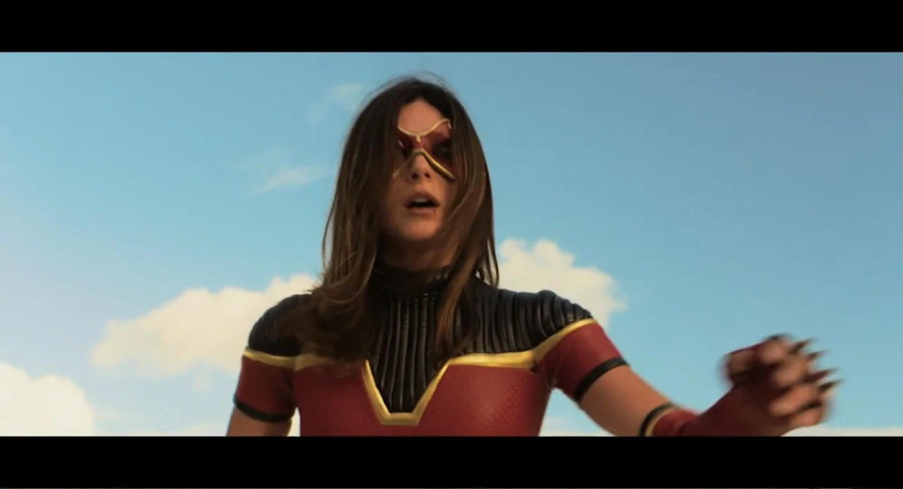 At Midnight (2023) movie still: medium — A figure stands outdoors against a clear blue sky with light scattered clouds. A woman in a superhero…