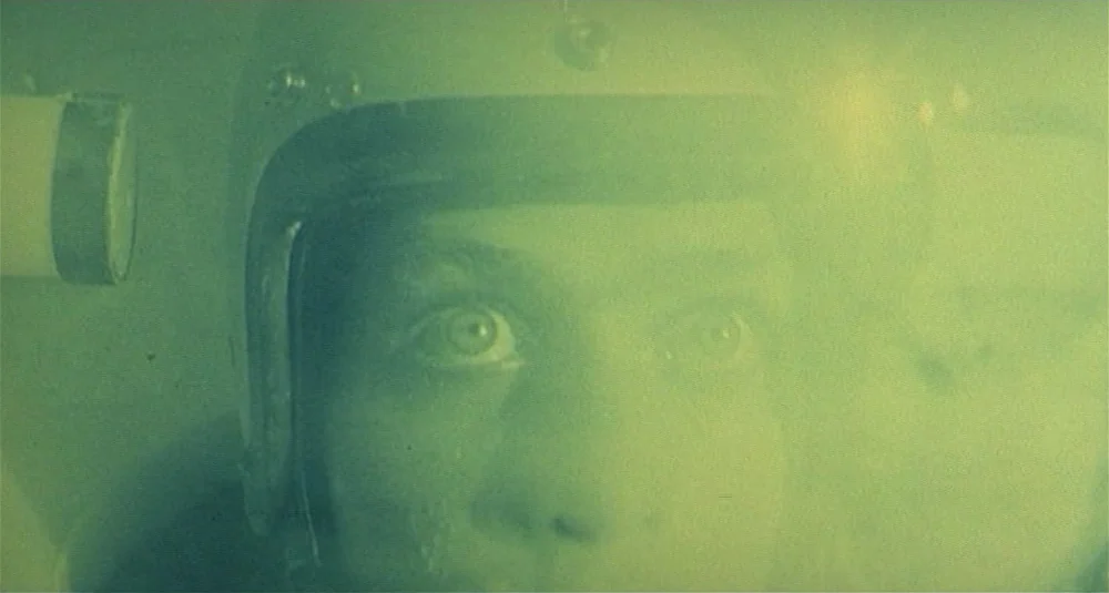Footprints (Le Orme) (1975) movie still: closeup — A close view of a man inside a pressurized helmet during a space flight. The man is looking ahead…