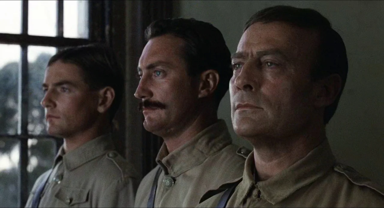 Breaker Morant (1980) movie still: medium — Three soldiers in 1940s military uniforms stand in a line against a wall. The men look ahead in a…