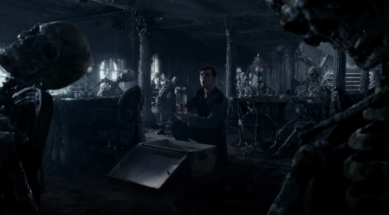 Miss Peregrine’s Home for Peculiar Children (2016) movie still: medium — A decrepit, dust-covered room contains multiple human skeletons seated…