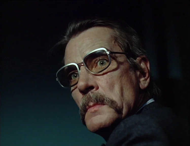The Arrival of Joachim Stiller (1976) movie still: closeup — A man stands in a dark, nondescript interior space. He looks toward the side of the…