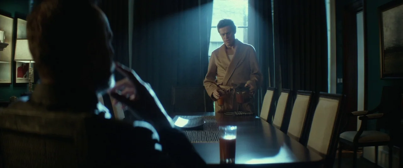 John Wick (2014) movie still: medium — A formal dining room features teal walls and a long mahogany table. A man in a beige bathrobe pours a drink…