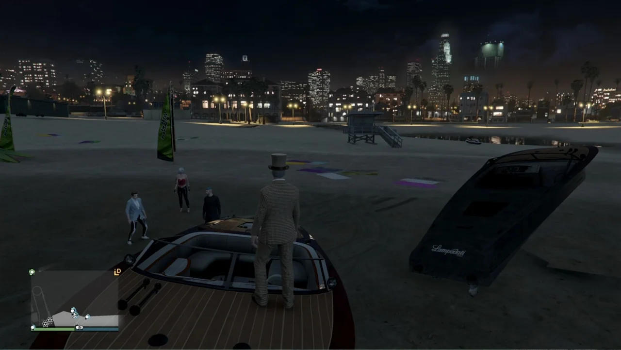 Grand Theft Hamlet (2024) movie still: wide — A dark sandy coastline features boats resting on the ground under a night city skyline. Four…