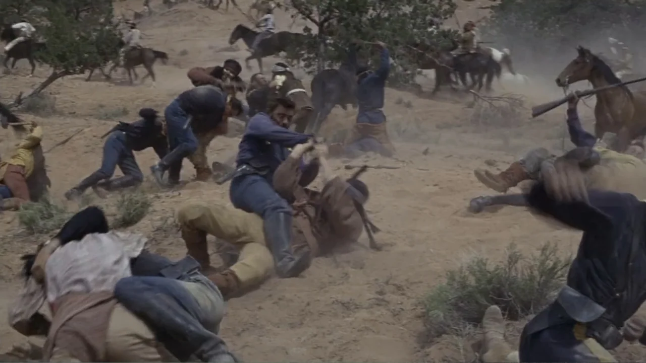 A Distant Trumpet (1964) movie still: wide — A dusty desert hillside features a large group of men fighting amidst dry vegetation. Multiple men in…