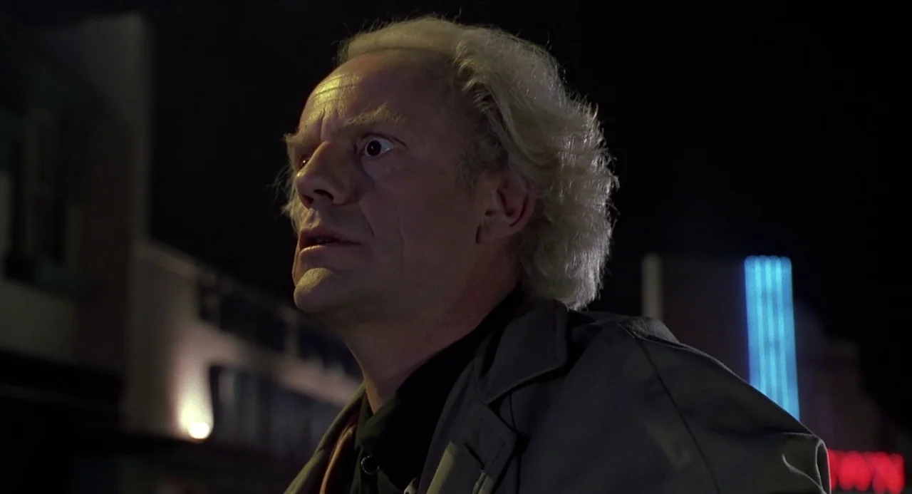 Back to the Future II (1989) movie still: A character is captured in a moment of sudden realization, his eyes wide with a mixture of fear and awe.…