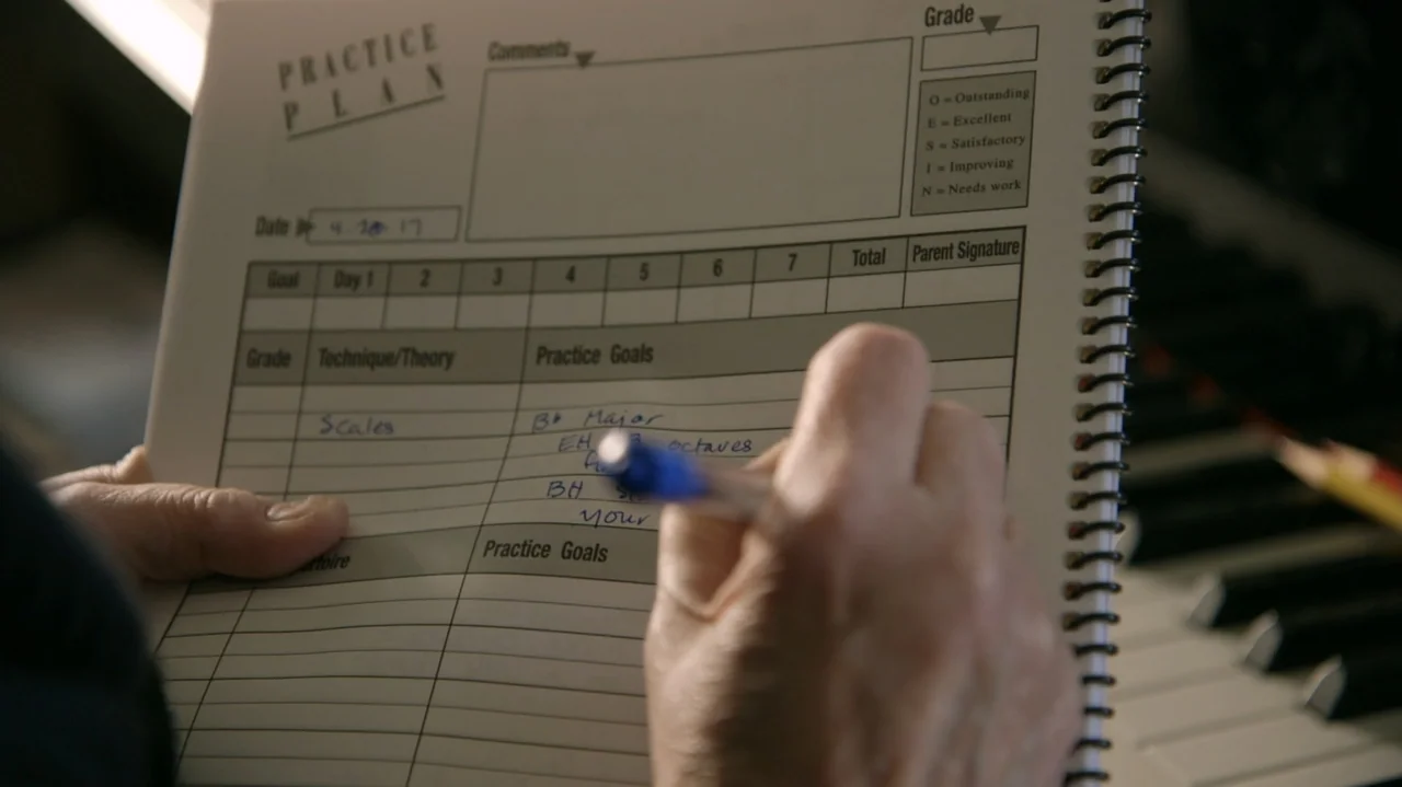 Moonlight Sonata: Deafness in Three Movements (2019) movie still: closeup — A close-up view shows a spiral-bound music practice log resting near a…