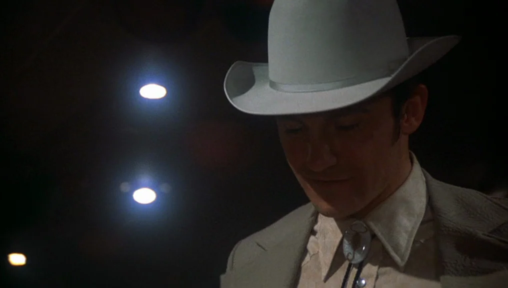 Alice Doesn’t Live Here Anymore (1974) movie still: closeup — A dark indoor space with blurred overhead light sources creating bokeh in the…