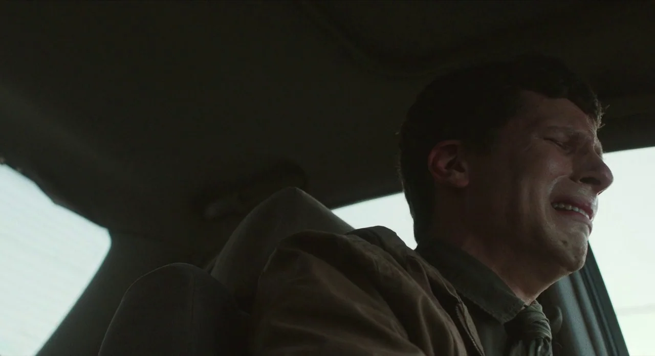 The Art of Self Defence (2019) movie still: medium — Inside a parked car during the day with bright light entering from the side window. A man with…
