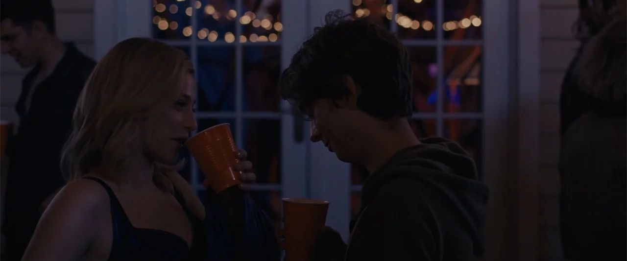 Chemical Hearts (2020) movie still: medium — A night scene on an outdoor patio featuring out of focus fairy lights behind two people. A young woman…