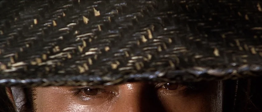 Lone Wolf and Cub: Baby Cart in the Land of Demons (1973) movie still: closeup — A close extreme crop shows only the eyes of a person under a hat.…