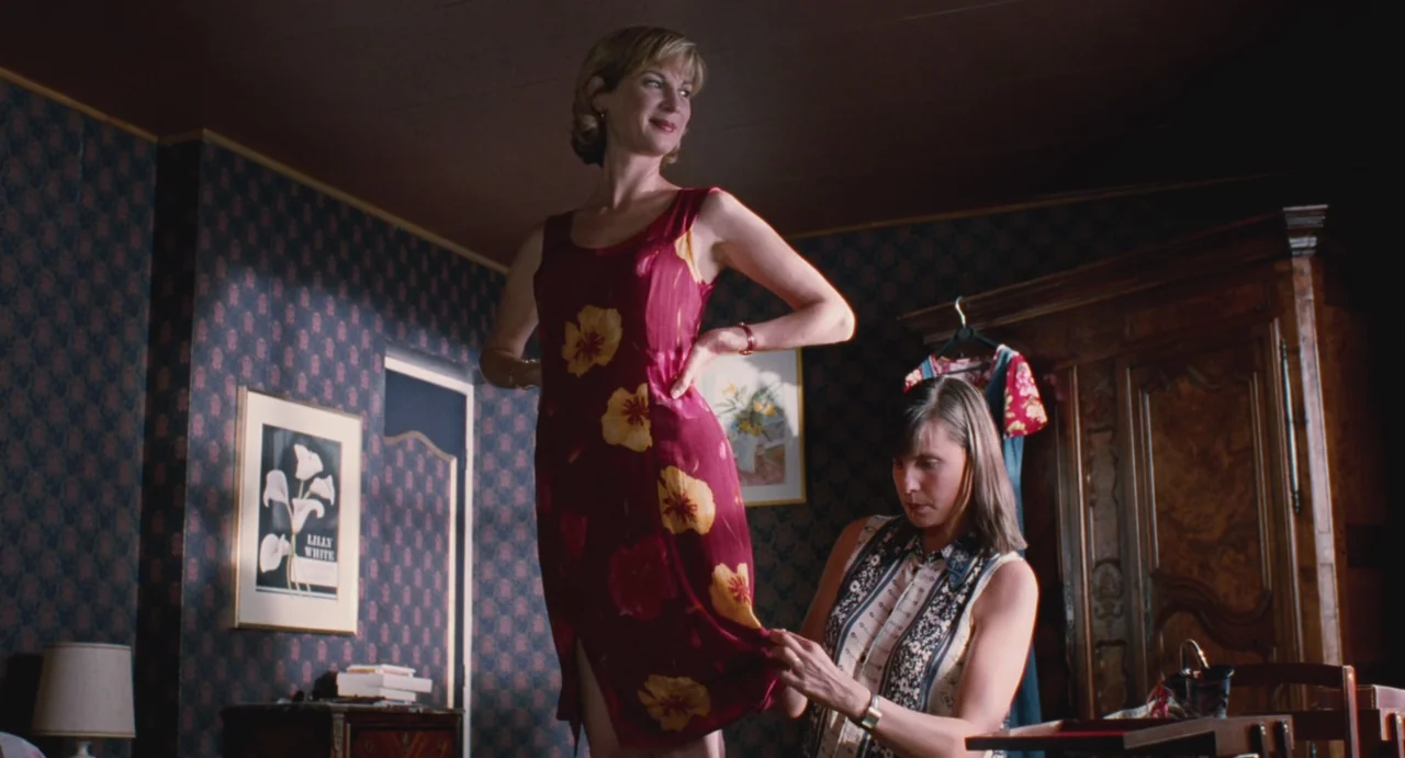 Ma Vie En Rose (1997) movie still: fullbody — A bedroom features patterned wallpaper and antique furniture including a large wooden wardrobe. One…