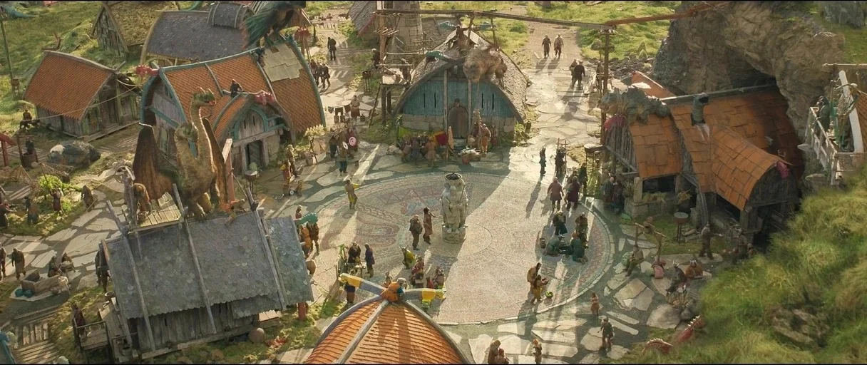 How to Train Your Dragon (2025) movie still: establishing — A Viking-style village with timber-framed houses and orange-tiled roofs nestled near a…