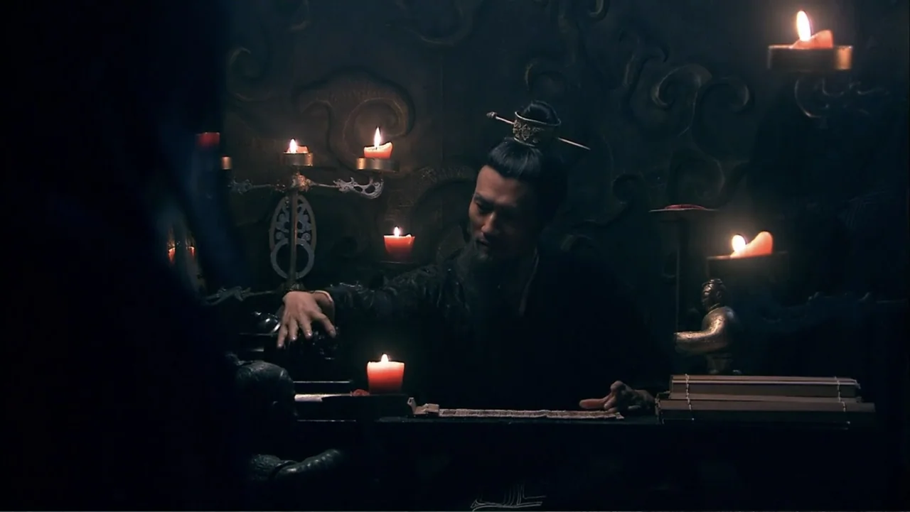 The First Emperor (2006) movie still: medium — A dimly lit room with carved dark walls is filled with glowing candle light. A man in historical…