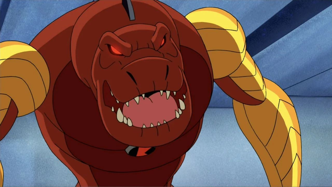 Ben 10: Ben 10,010 (2021) movie still: closeup — A stylized interior space with light blue wall panels. A red, dinosaur-like humanoid creature with…