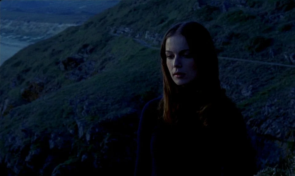 Successive Slidings of Pleasure (Glissements progressifs du plaisir) (1974) movie still: medium — A rugged coastal cliffside is visible behind a…