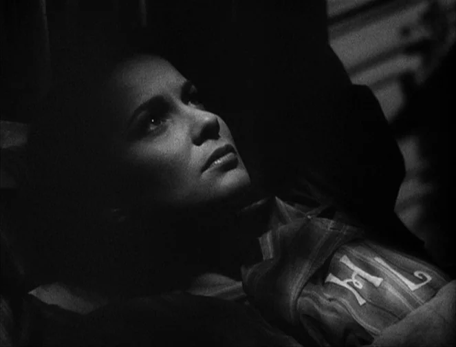 The Third Man (1949) movie still: closeup — A person lies in bed at night under low-key lighting. The figure looks upward while resting against…